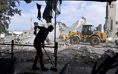 Un Palestinien balaie le sol de sa maison à Beit Lahia, dans le nord de la bande de Gaza, en août 2014. Illustration. (Crédit : Roberto Schmidt/AFP)