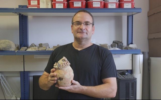Danny Rosenberg, professeur à l'université de Haïfa, avec le modèle de silo en argile, vieux de 7 200 ans, retrouvé à Tel Tsaf, dans la vallée du Jourdain. (Crédit : Haifa University)