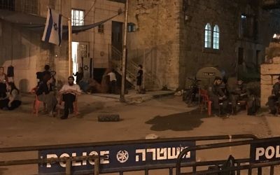 Les squatters de la maison Machpela de Hébron, devant les garde-frontières, le 26 juillet 2017. (Crédit : Jacob Magid/Times of Israël)
