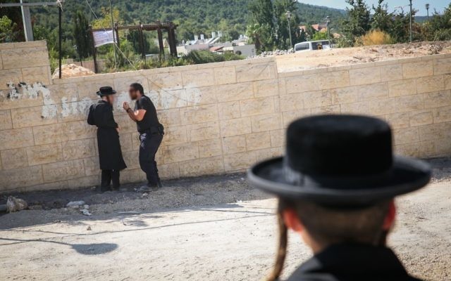 Illustration : altercation entre un policier et un manifestant ultra-orthodoxe sur un chantier à Méron, dans le nord d'Israel, le 16 août 2017. (Crédit : David Cohen/Flash90) Illustration : altercation entre un policier et un manifestant ultra-orthodoxe sur un chantier à Méron, dans le nord d'Israel, le 16 août 2017. (Crédit : David Cohen/Flash90)