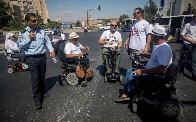 Des handicapés et des militants bloquent l'entrée à Jérusalem lors d'une manifestation réclamant de meilleurs soins de santé, le 7 septembre 2017 (Crédit : Yonatan Sindel/Flash90) Des handicapés et des militants bloquent l'entrée à Jérusalem lors d'une manifestation réclamant de meilleurs soins de santé, le 7 septembre 2017 (Crédit : Yonatan Sindel/Flash90)