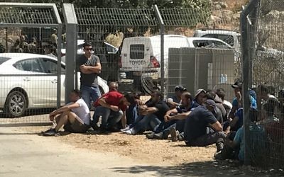 Des travailleurs palestiniens devant l'implantation de Har Adar, après l'attentat terroriste meurtrier du 26 septembre 2017. (Crédit : Jacob Magid/Times of Israël)