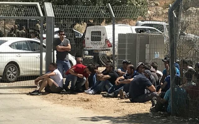 Des travailleurs palestiniens devant l'implantation de Har Adar, après l'attentat terroriste meurtrier du 26 septembre 2017. (Crédit : Jacob Magid/Times of Israël)