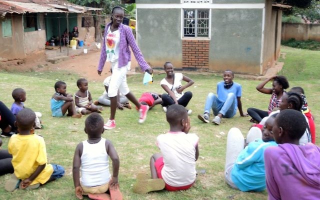 Les élèves de Come True, qui ont été expulsés d'Israël, organisent une journée de jeux dans un orphelinat de Kampala le 1er septembre 2017 (Crédit :  Melanie Lidman/Times of Israel)