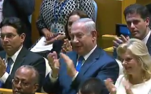 Le Premier ministre Benjamin Netanyahu, avec sa femme Sara, et l'ambassadeur israélien aux Nations unies Danny Danon, applaudissent après l'allocution du président américain Donald Trump, lors de la 72ème Assemblée générale de l'ONU à New York, le 19 septembre 2017. (Crédit : capture d'écran YouTube) Le Premier ministre Benjamin Netanyahu, avec sa femme Sara, et l'ambassadeur israélien aux Nations unies Danny Danon, applaudissent après l'allocution du président américain Donald Trump, lors de la 72ème Assemblée générale de l'ONU à New York, le 19 septembre 2017. (Crédit : capture d'écran YouTube)