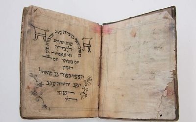 Une Haggadah de Pessah, de 1902, l'un des rares manuscrits en hébreu extirpés d'une cave inondée, de Mukhabarat, les quartiers généraux des services secrets de Saddam Hussein, décorée à la main par un jeune irakien. (Crédit : U.S. National Archives)