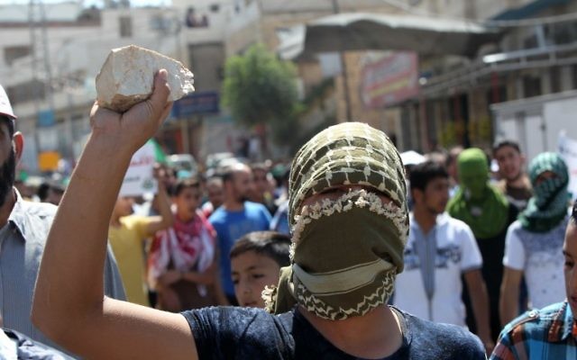 Un Palestinien, pierre à la main, à Hébron, le 18 septembre 2015. Illustration. (Crédit : Hazem Bader/AFP)