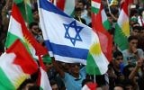 Illustration : Des Kurdes irakiens brandissant un drapeau d'Israël et des drapeaux kurdes lors d'un événement pour inciter les gens à voter lors du référendum pour l'indépendance à Arbil, la capitale de la région autonome kurde au nord de l'Irak, le 16 septembre 2017 (Crédit : Safin Hamed/AFP)