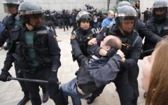 La Garde civile espagnole traîne un homme hors d'un bureau de vote à Sant Julia de Ramis, où devait voter le président catalan, le 1er octobre 2017. (Crédit : Raymond Roig/AFP)