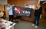 La directrice exécutive de l'ICAN, Beatrice Fihn (à droite) et le coordinateur Daniel Hogstan, tiennent une bannière avec le logo du groupe pour le désarmement nucléaire après que l'ICAN a remporté le prix Nobel de la paix pour sa campagne pour éliminer les armes nucléaires, le 6 octobre 2017, à Genève, Suisse (Crédit : AFP PHOTO / Fabrice COFFRINI)