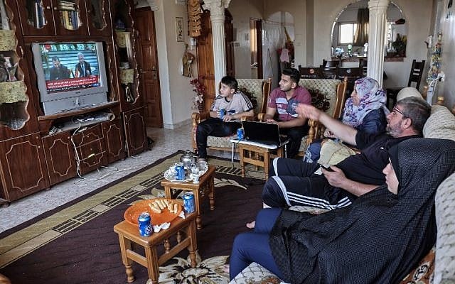 Des Palestiniens regardent à la télévision la signature d'un accord de réconciliation au Caire entre des factions palestiniennes rivales, le Hamas et le Fatah, le 12 octobre 2017 à Rafah, dans le sud de la bande de Gaza. (Crédit : AFP / SAID KHATIB) Des Palestiniens regardent à la télévision la signature d'un accord de réconciliation au Caire entre des factions palestiniennes rivales, le Hamas et le Fatah, le 12 octobre 2017 à Rafah, dans le sud de la bande de Gaza. (Crédit : AFP / SAID KHATIB)