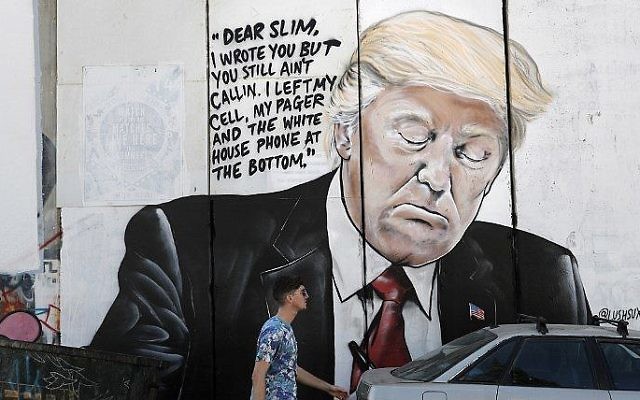Un nouveau graffiti sur la barrière de sécurité israélienne, représentant le président américain Donald Trump, à Bethléem, en Cisjordanie, le 15 octobre 2017. (Crédit : Thomas Coex/AFP) Un nouveau graffiti sur la barrière de sécurité israélienne, représentant le président américain Donald Trump, à Bethléem, en Cisjordanie, le 15 octobre 2017. (Crédit : Thomas Coex/AFP)