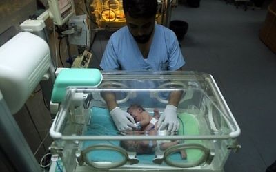 Des jumelles siamoises palestiniennes dans une couveuse le 22 octobre 2017 à l'hôpital al-Shifa de la ville de Gaza (Crédit : MAHMUD HAMS / AFP)