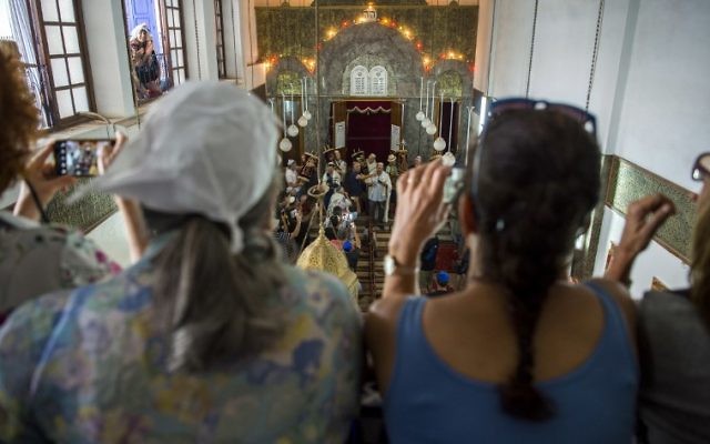 Des Juifs marocains et des touristes juifs israéliens pendant la fête de Simchat Torah à la synagogue de Marrakech, le 12 octobre 2017. (Crédit : Fadel Senna/AFP)