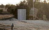 Soldat israélien devant une batterie du Dôme de Fer déployé au niveau du kibboutz Kissufim, près de la frontière gazaouie, le 30 octobre 2017. (Crédit : Menahem Kahana/AFP)
