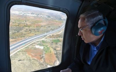 Le Premier ministre Benjamin Netanyahu lors d'un vol en hélicoptère, dans le cadre d'une visite de la région de Gush Etzion et de la brigade Etzion de l'armée israélienne, le 23 novembre 2015. (Haim Zach/GPO)