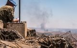 Un observateur de l'ONU installé à un poste de guet regarde la fumée qui s'élève d'un village syrien à proximité de la frontière israélo-syrienne dans les combats entre les rebelles et l'armée syrienne sur le plateau du Golan, le 25 juin 2017 (Crédit :Basel Awidat/Flash90)