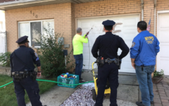 Nettoyage d'une croix gammée sur la porte d'un garage d'une maison de Staten Island, en octobre 2017. (Crédit : NYPD 23rd Precinct via JTA)