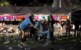 Un homme en chaise roulante est conduit vers la sortie du festival Route 91 Harvest, après des coups de feu, à Las Vegas, dans le Nevada, le 1er octobre 2017. (Crédit : David Becker/Getty Images/AFP)