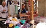 Un homme irakien tisse un tapis dans son atelier de textile dans la ville irakienne de Hilla, au sud de Bagdad, le 12 octobre 2017 (Crédit : AFP PHOTO / SABAH ARAR)