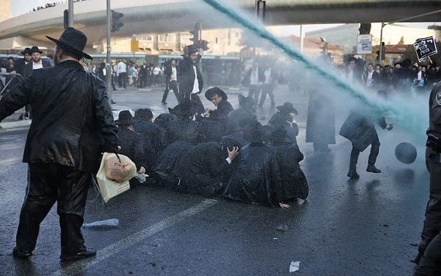 La police pulvérise de l'eau pour tenter de disperser une manifestation de Juifs ultra-orthodoxes contre la conscription de membres de leur communauté, à l'entrée de Jérusalem le 23 octobre 2017. (Crédit : AFP / Ahmad Gharabli) La police pulvérise de l'eau pour tenter de disperser une manifestation de Juifs ultra-orthodoxes contre la conscription de membres de leur communauté, à l'entrée de Jérusalem le 23 octobre 2017. (Crédit : AFP / Ahmad Gharabli)