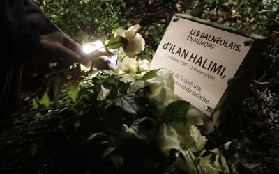Une personne pose une rose blanche sur la nouvelle plaque  en hommage à Ilan Halimi le 7 novembre 2017 à Bagneux, près de Paris, après une profanation de la plaque commémorative qui a eu lieu le 1er novembre. (Crédit : AFP / Thomas SAMSON)