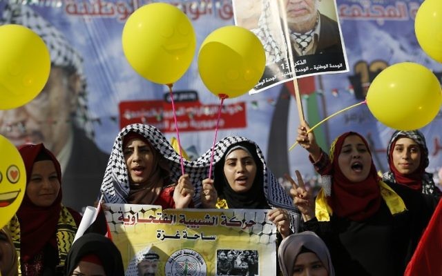 Les palestiniens brandissent des photos de Yasser Arafat à l’occasion du 13ème anniversaire de sa mort, à Gaza-Ville le 9 novembre 2017. (Crédit : AFP/Mohammed ABED)