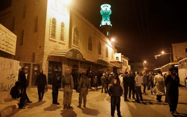 Quelque 400 Juifs ultra-orthodoxes sont entrés dans la zone contrôlée par les Palestiniens sous l'escorte de l'armée israélienne pour prier sur les tombeaux de deux prophètes bibliques. (Crédit : AFP / MENAHEM KAHANA)