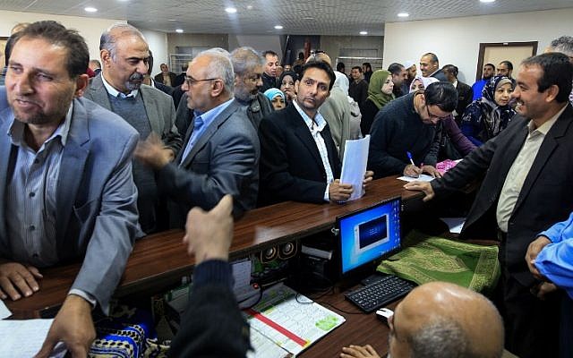 Les fonctionnaires de l'Autorité palestinienne se réunissent pour reprendre leur travail aux quartiers généraux du ministère des Finances à Gaza-Ville, le 29 novembre 2017. (Crédit : AFP PHOTO / MOHAMMED ABED Les fonctionnaires de l'Autorité palestinienne se réunissent pour reprendre leur travail aux quartiers généraux du ministère des Finances à Gaza-Ville, le 29 novembre 2017. (Crédit : AFP PHOTO / MOHAMMED ABED