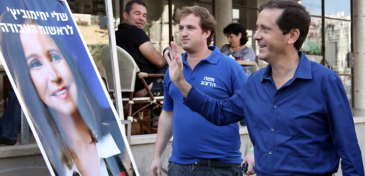 Le député israélien Isaac Herzog se tient devant une affiche électorale pour le chef du parti, Shelly Yachimovich, alors que le parti organise des élections primaires le 21 novembre 2013 (Crédit : Gideon Markowicz / Flash90)