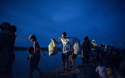 Cette photo prise le 9 octobre 2017 montre des réfugiés Rohingya marchant après avoir traversé la rivière Naf du Myanmar au Bangladesh à Whaikhyang le 9 octobre 2017. (Crédit : AFP/FRED DUFOUR)