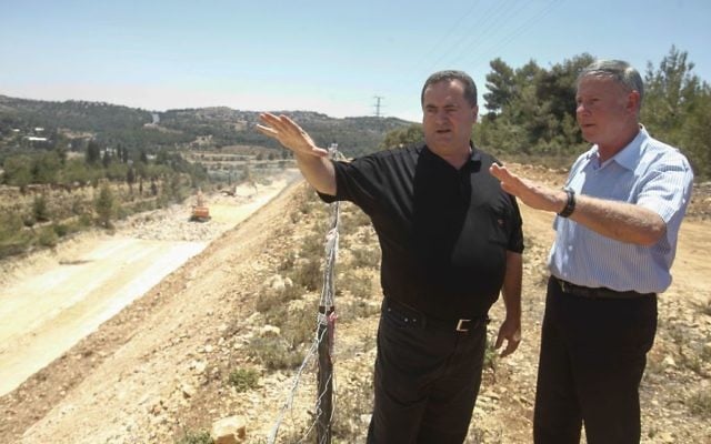 Le ministre des Transports Yisrael Katz, au centre, avec le directeur-général de Netivei Israel Shai Baras, lqui a été ultérieurement arrêté pour népotisme, alors qu'ils inspectaient la construction d'une nouvelle autoroute entre Jérusalem et Tel Aviv, le 12 juin 2013 (Crédit : Flash 90)