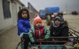 Des enfants réfugiés arrivant à la frontière turque alors que des Syriens fuyant la ville assiégée d'Alep attendent pour passer la frontière, à Bab al-Salama, près de la ville d'Azaz, au nord de la Syrie,  le 6 février 2016. (Crédit : Bulent Kilic/AFP)