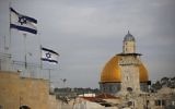 Les drapeaux israéliens flottent au vent alors que le Dôme du Rocher est vu en arrière-plan, dans la Vieille Ville de Jérusalem, le 5 décembre 2017. (Crédit : AFP / Thomas Coex)