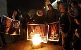 Des manifestants palestiniens brûlent des photos du président Donald Trump sur la place Manger de Bethléem le 5 décembre 2017 (Crédit : AFP Photo/Musa Al Shaer)