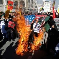 Des manifestants iraniens enflamment un drapeau américain lors d'une manifestation contre la reconnaissance de Jérusalem comme capitale d'Israël, à Téhéran, le 8 décembre 2017. (Crédit : AFP/STR)