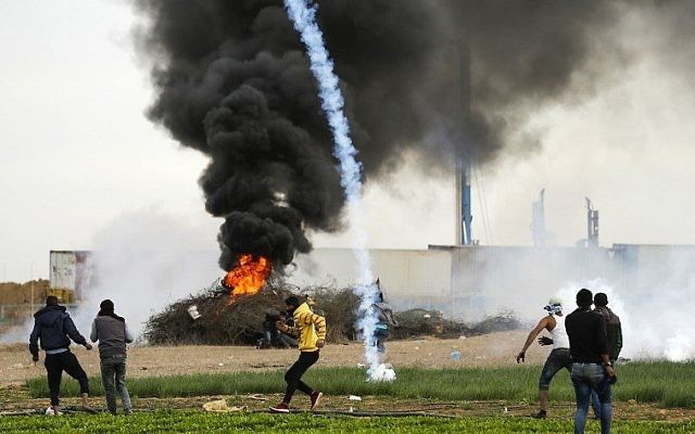 Une photo prise le 10 décembre 2017 montre une cartouche de gaz lacrymogène tombant près des manifestants palestiniens lors d'affrontements avec les forces israéliennes près de la frontière entre Israël et Gaza à l'est de la ville de Khan Yunis, dans le sud de la bande de Gaza (Crédit : PHOTO AFP / MAHMUD HAMS)