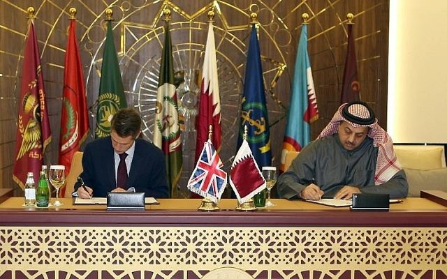Le ministre de la Défense du Qatar Khalid bin Mohammed al-Attiyah, à droite, signe un accord avec son homologue britannique  Gavin Williamson pour acheter 24 avions Typhoon au Royaume-Uni dans la capitale de Doha, le 10 décembre 2017 (Crédit : AFP Photo/Stringer)