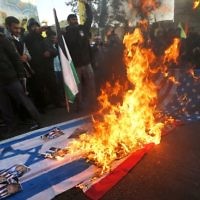 Des manifestants iraniens ont mis le feu aux drapeaux israéliens lors d'une manifestation dans la capitale de Téhéran, le 11 décembre 2017 pour dénoncer la déclaration de Jérusalem par le président américain Donald Trump comme capitale d'Israël. (Crédit : AFP / ATTA KENARE)