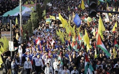 Des partisans du Hezbollah brandissent des drapeaux palestiniens et des drapeaux du Hezbollah durant une manifestation contre la reconnaissance de Jérusalem comme capitale d'Israël par Trump, à Beyrouth le 11 décembre 2017. (Crédit : AFP/Joseph EID)