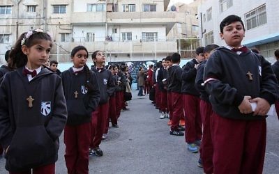 Des élèves chrétiens irakiens alignés dans la cour de l'école du Patriarcat latin dans le district de Marka dans la partie orientale de la capitale Amman, le 12 décembre 2017. (Crédit : AFP / Khalil Mazraawi)