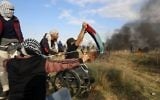 Le manifestant palestinien handicapé  Ibrahim Abu Thurayeh brandit un drapeau palestinien durant une manifestation le long de la frontière avec Gaza le 15 décembre 2017 dans des affrontements qui suivent la reconnaissance de Jérusalem comme capitale d'Israël du président américain Donald Trump (Crédit : MOHAMMED ABED / AFP)