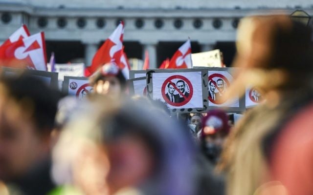 Des manifestants brandissent des bannières dénonçant le futur chancelier Sebastian Kurz et le prochain vice-chancelier du parti d'extrême-droite de la Liberté (FPO) Christian Strache durant une manifestation contre le nouveau gouvernement autrichien aux abords du palais présidentiel durant l'investiture du nouveau gouvernement autrichien à Vienne, en Autriche, le 18 décembre 2017 (Crédit : AFP PHOTO / JOE KLAMAR)