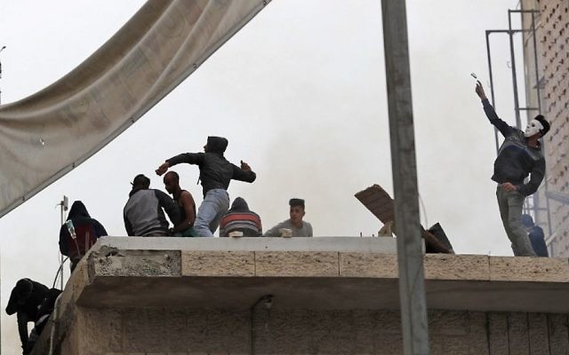 Des manifestants palestiniens affrontent les forces de l'ordre israéliennes près du checkpoint de Qalandiya, en Cisjordanie, le 20 décembre 2017, après la reconnaissance de Jérusalem comme capitale d'Israël par Donald Trump. (Crédit : AFP / ABBAS MOMANI)