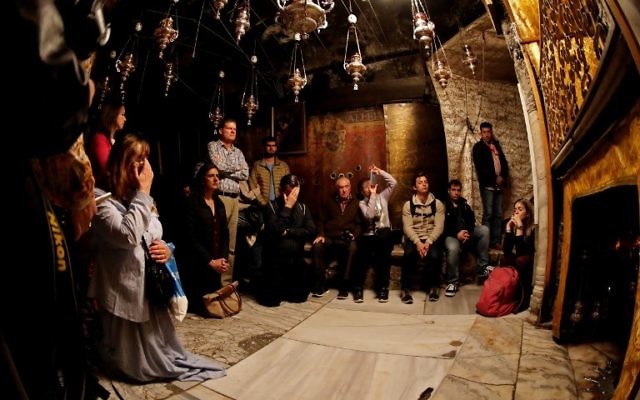 Les fidèles chrétiens prient près de l'étoile d'argent à 14 branches dans la Grotte, considérée comme l'endroit exact où Jésus Christ est né, dans l'église de la Nativité à Bethléem en Cisjordanie, le 21 décembre 2017 (Crédit : AFP PHOTO / THOMAS COEX)