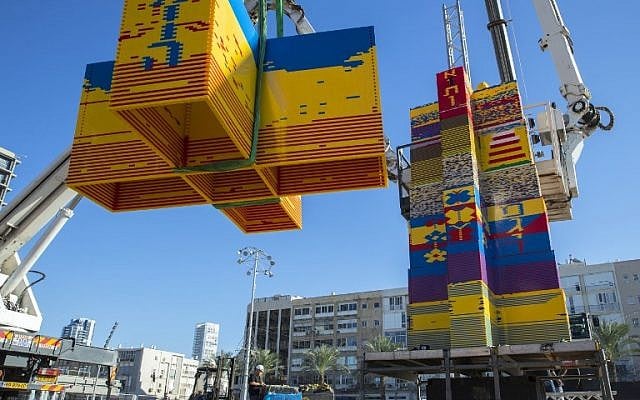 Des ouvriers et des bénévoles aident à assembler des briques de LEGO sur la place Rabin, à Tel Aviv, le 27 décembre 2017, alors que a ville tente de battre un record. (Crédit : AFP / JACK GUEZ)