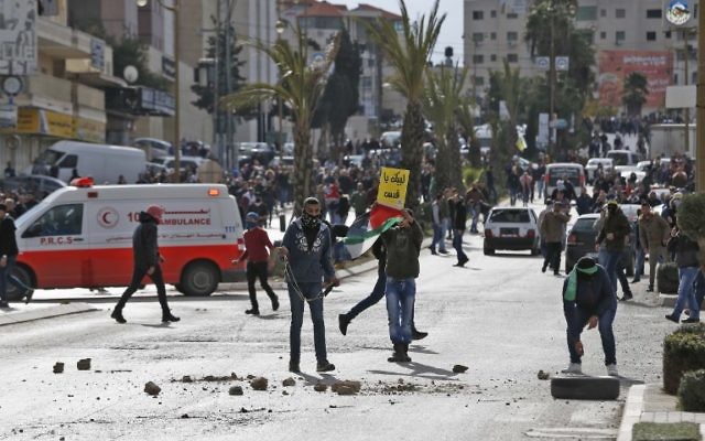 Des manifestants palestiniens lors d’affrontements avec les forces israéliennes près d'un poste de contrôle dans la ville de Ramallah, en Cisjordanie, le 7 décembre 2017 (ABBAS MOMANI / AFP)