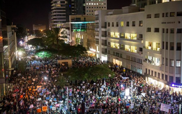 Des Israéliens brandissent des pancartes et scandent des slogans lors d'une manifestation contre la corruption, à Tel Aviv le 23 décembre 2017. (Crédit : Miriam Alster / Flash90)