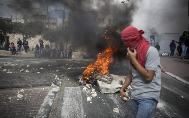 Un jeune palestinien tient des pierres à la main durant un affrontement avec la police israélienne dans le quartier de Sur Baher, à Jérusalem-est, le 7 octobre 2015 (Crédit : Hadas Parush/Flash90)