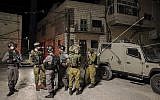 Des milliers d'hommes juifs ultra-orthodoxes sont entrés dans le village palestinien de Kifl Haris, en Cisjordanie, accompagnés de soldats israéliens, pour prier sur les tombes de Yehoshua Ben Nun et Kaleb Ben Yefune, le 3 mai 2016. (Crédit : Yaakov Naumi / Flash90)